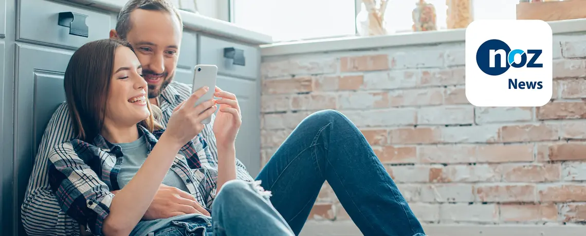 Paar schaut auf Smartphone News App