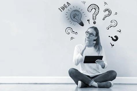 Eine Frage mit einem Tablet, die nachdenklich aussieht. Hinter ihr an der Wand stehen Fragezeichen